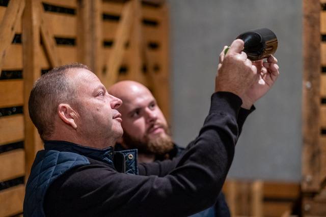 Dos hombres viendo a contraluz la botella de champagne
